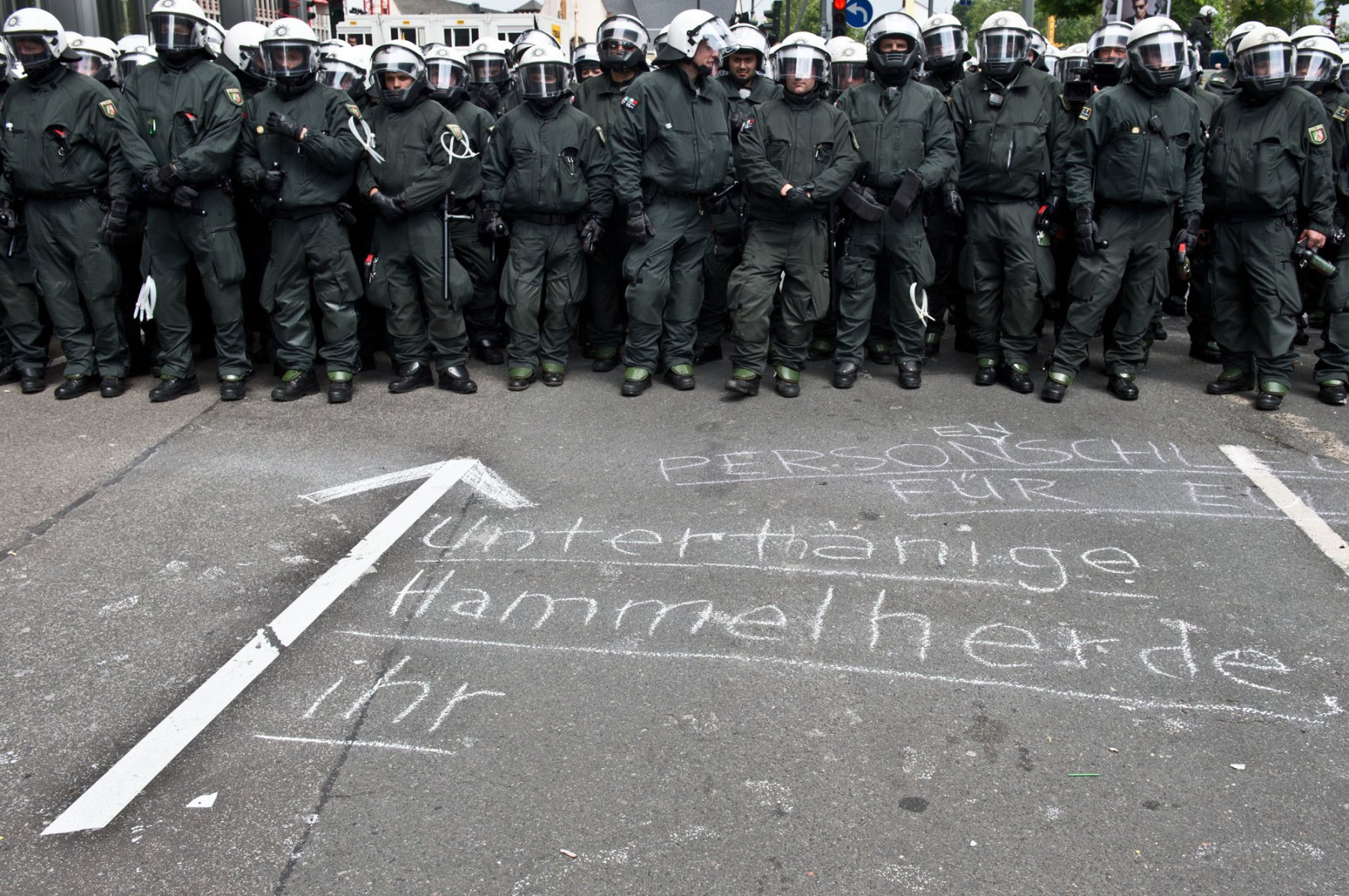 "Untertänige Hammelherde des Systems" haben Demonstranten der Blockupy-Bewegung am 01.06.2013 in der Innenstadt von Frankfurt am Main (Hessen) vor die Beamten einer Hundertschaft auf die Straße geschrieben.  Foto: Boris Roessler/dpa