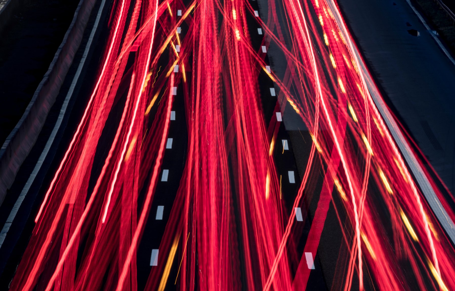 Die Scheinwerfer vorbeifahrender Fahrzeuge ziehen auf der Autobahn 5 bei Frankfurt Leuchtstreifen durch die Dunkelheit.