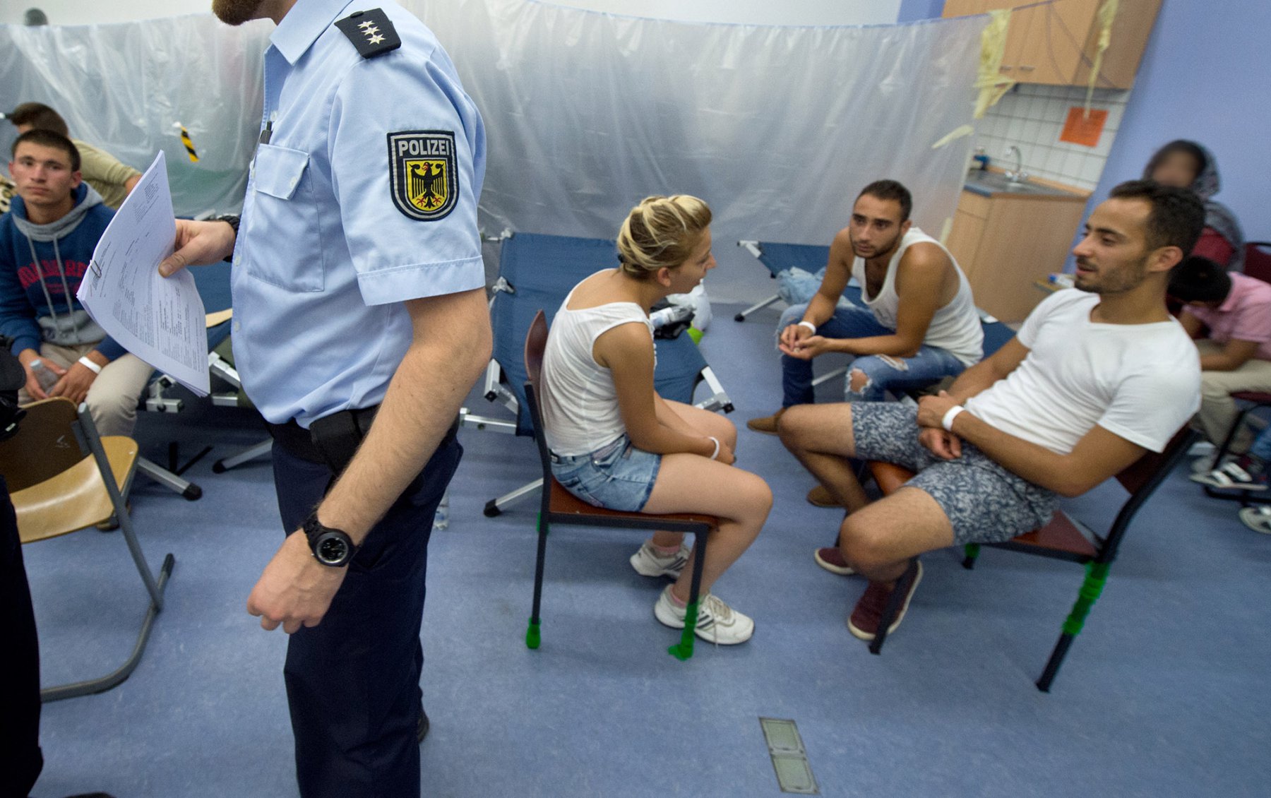 Aus Afghanistan und Syrien stammen Flüchtlinge, die in einem Raum der Bundespolizei auf der Wache am Hauptbahnhof von Frankfurt auf ihre Erfassung warten. Foto: Boris Roessler/dpa 