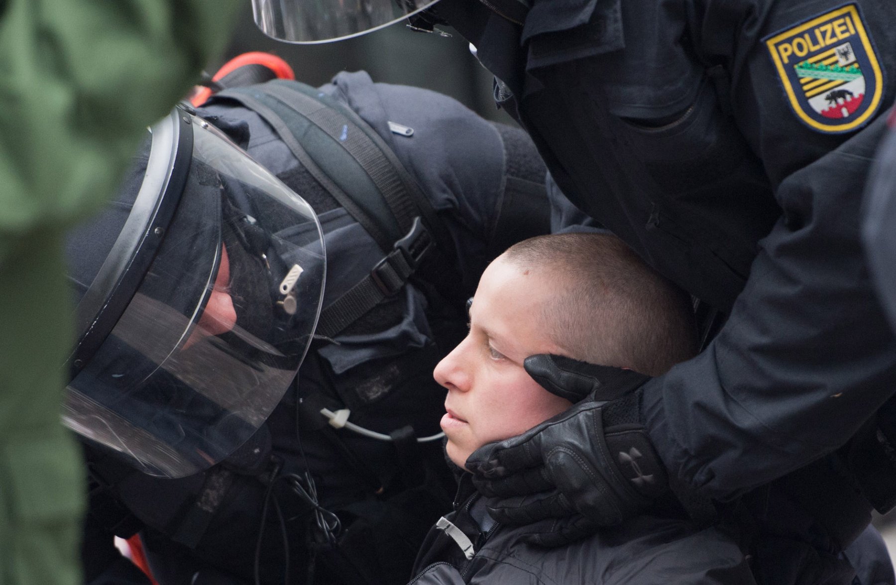 Um eine kollabierte Demonstrantin der Blockupy-Bewegung kümmern sich Polizisten am 01.06.2013 in der Innenstadt von Frankfurt am Main (Hessen) nach der gewaltsamen Auflösung eines Polizeikessels. Die Polizei ist mit einem massiven Kräfteaufgebot vor Ort. Foto: Boris Roessler/dpa