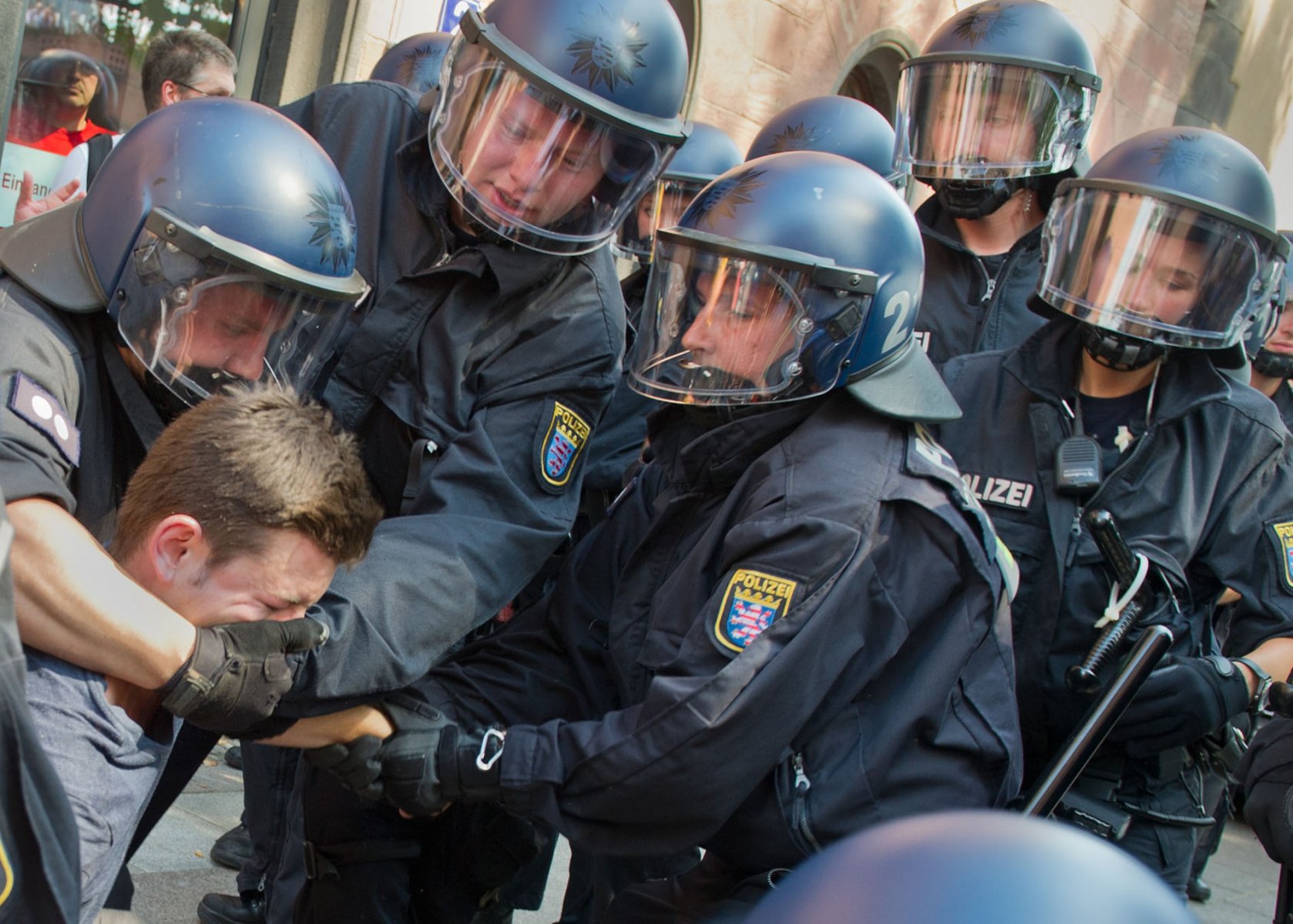 Polizisten versuchen am Freitag (27.07.2012) in Frankfurt am Main eine Sitzblockade von NPD-Gegnern aufzulösen. Mehrere hundert Menschen hatten verhindert, dass die NPD auf ihrer sogenannten "Deutschlandtour" mit einem Lautsprecherwagen auf den Frankfurter Römerberg gelangen konnte. Foto: Boris Roessler dpa/lhe  +++(c) dpa - Bildfunk+++