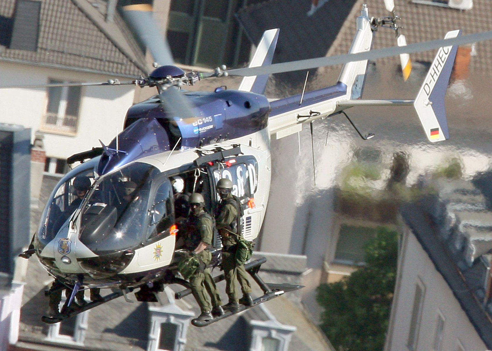 Auf den Kufen eines Hubschraubers, eines EC 145 von eurocopter, stehen vermummte Polizisten des Spezialeinsatzkommandos (SEK) der hessischen Polizei über der Innenstadt von Frankfurt am Main. Das SEK trainierte unter anderem den verdeckten Anflug auf Wolkenkratzer und das blitzschnelle Abseilen der Beamten auf die Dächer der Hochhäuser. Frankfurt gilt innerhalb Deutschlands als besonders gefährdetes Ziel für eventuelle terroristischen Anschläge. Foto: Boris Roessler/dpa