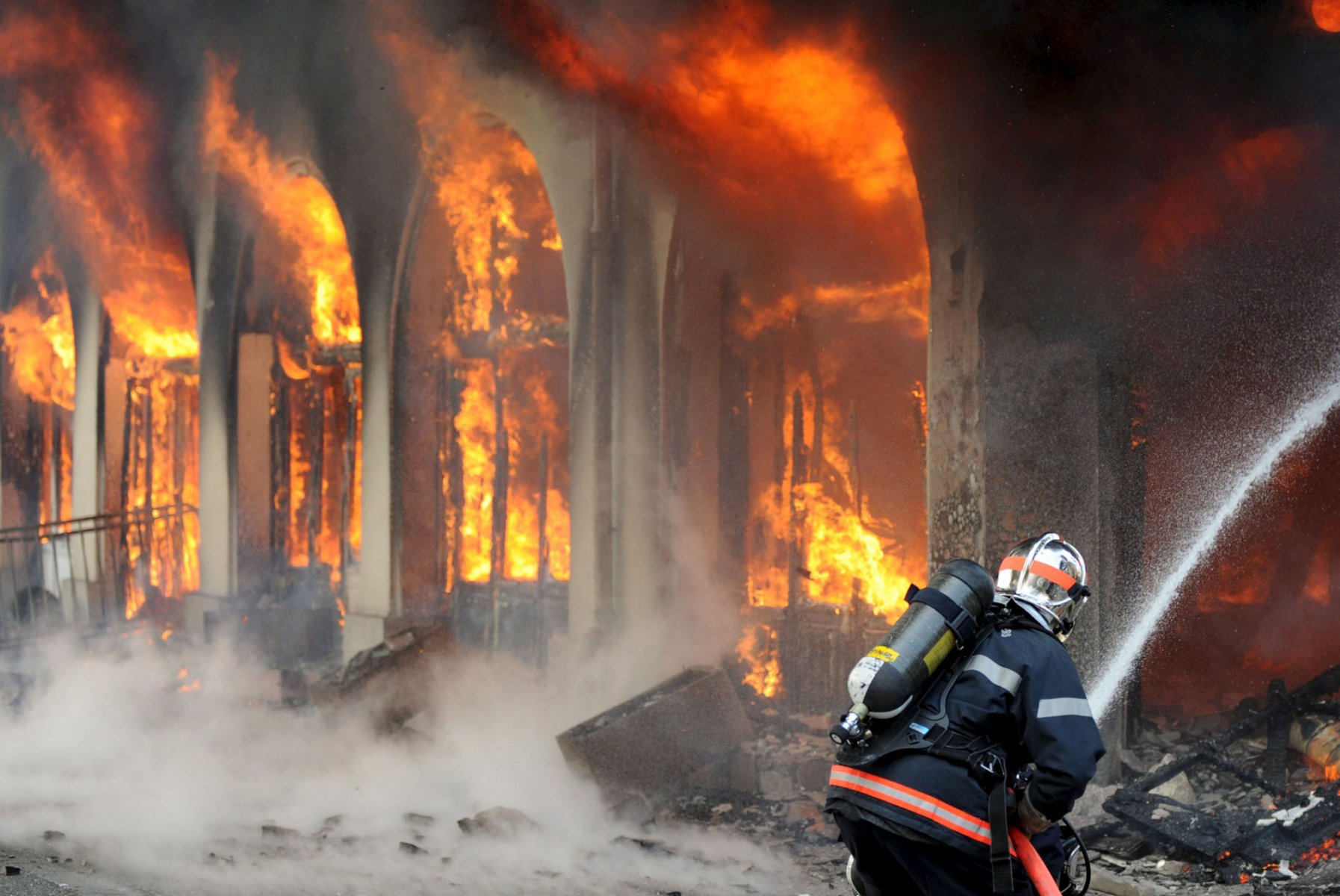 Firefighters extinguish flames in a hotel set afire by demonstrators at the NATO Summit in Strasbourg, France. EPA/BORIS ROESSLER