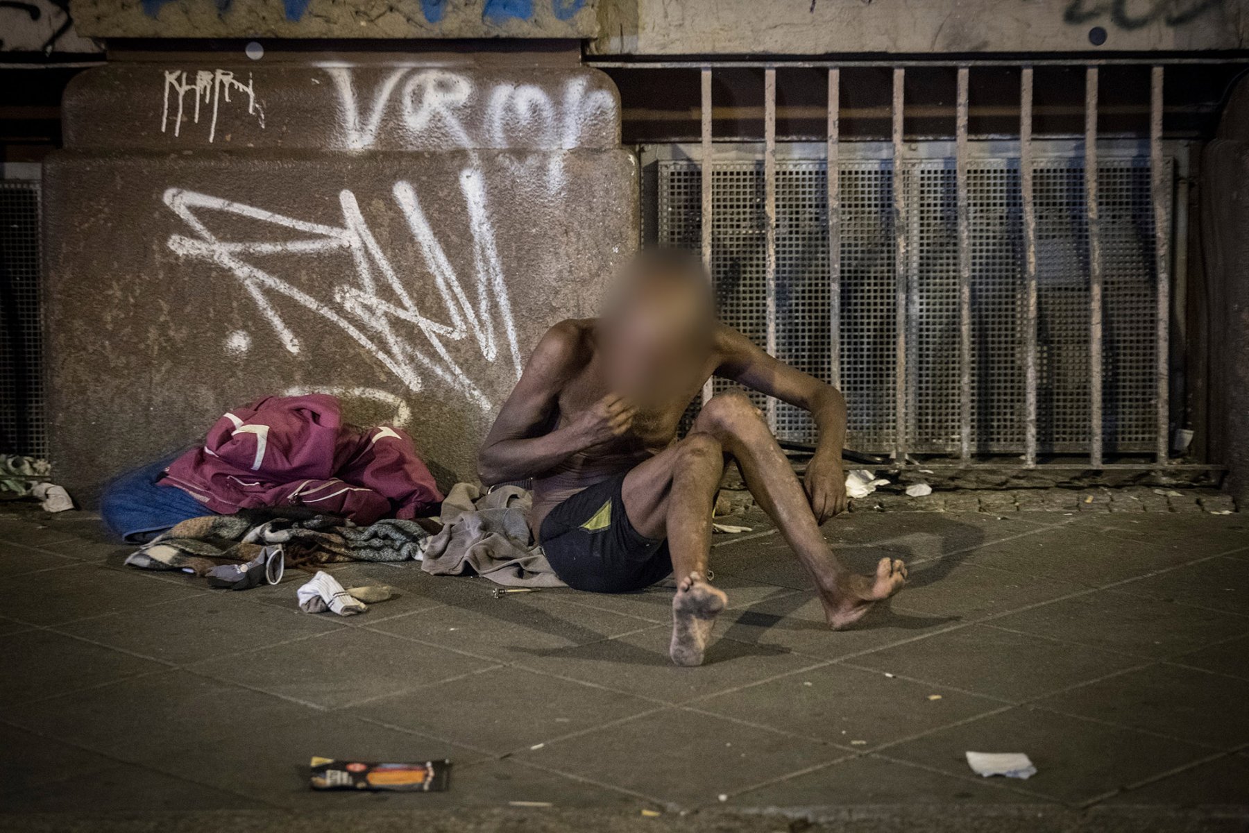 Frankfurt, Bahnhofsviertel, August 2018: Fast nackt sitzt ein Junkie inmitten von Müll auf dem Bürgersteig. Foto: Boris Roessler/dpa